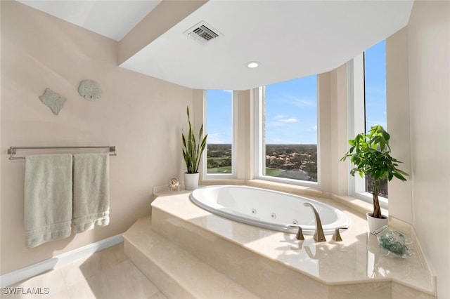 bathroom with tile patterned flooring and a relaxing tiled tub