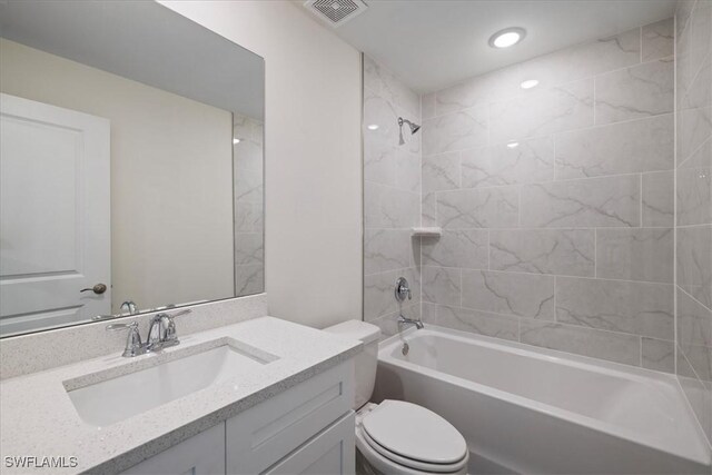 full bathroom featuring vanity, toilet, and tiled shower / bath