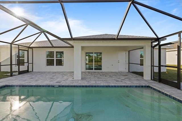 view of swimming pool featuring a patio and glass enclosure