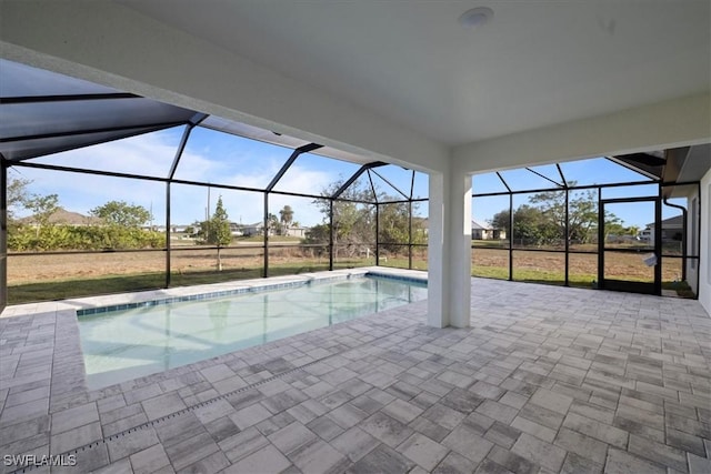 view of swimming pool featuring a patio and glass enclosure