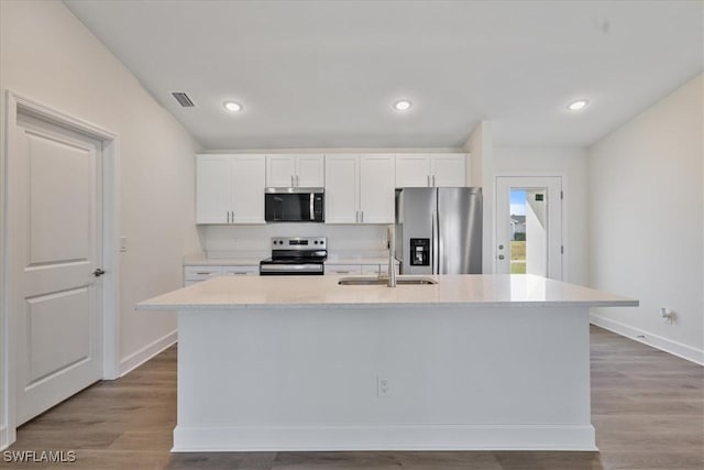 kitchen with a kitchen island with sink, white cabinetry, sink, and stainless steel appliances