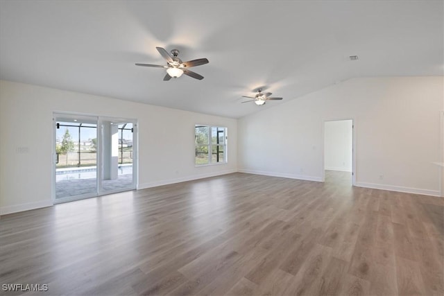 unfurnished room with plenty of natural light, ceiling fan, hardwood / wood-style floors, and vaulted ceiling