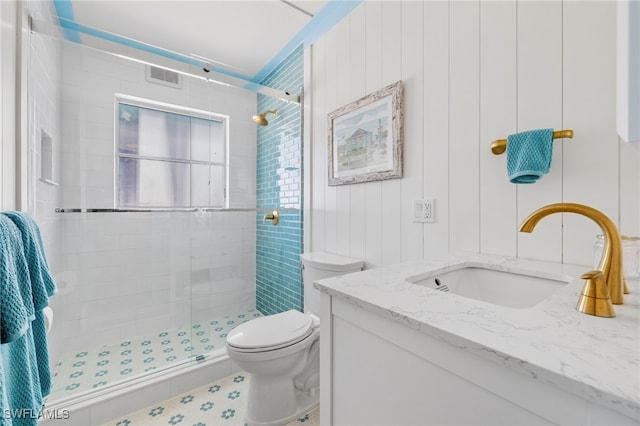 bathroom with vanity, a shower with shower door, and toilet