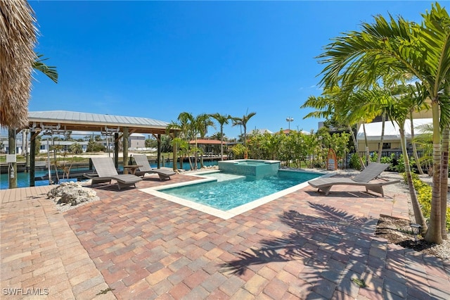 view of pool with a patio area, an in ground hot tub, and a water view