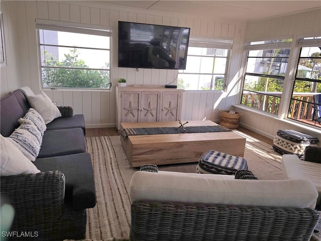 living room with hardwood / wood-style flooring and wooden walls