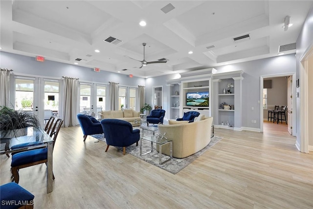 living room with coffered ceiling, french doors, light hardwood / wood-style flooring, ceiling fan, and built in shelves