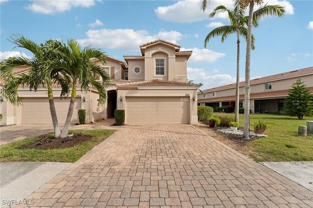 mediterranean / spanish house featuring a garage and a front lawn