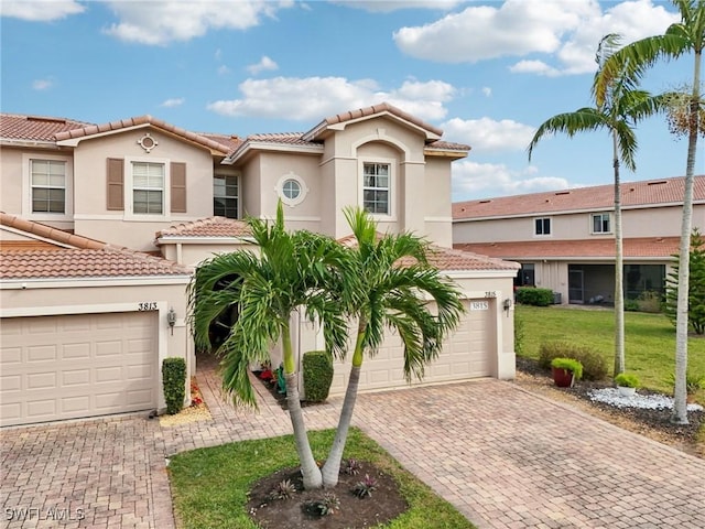 mediterranean / spanish-style house with a garage and a front lawn