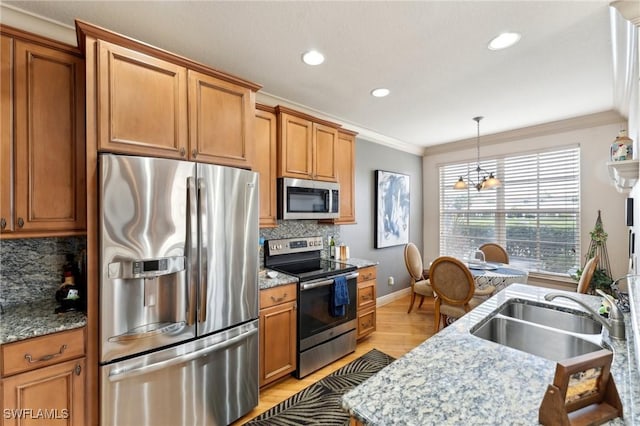 kitchen with a chandelier, stainless steel appliances, tasteful backsplash, and sink