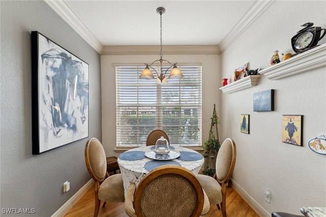 dining area featuring light hardwood / wood-style flooring, an inviting chandelier, and crown molding