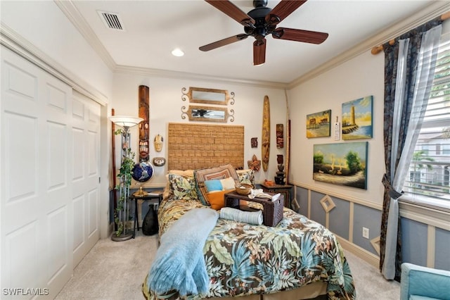 carpeted bedroom featuring a closet, ceiling fan, and crown molding