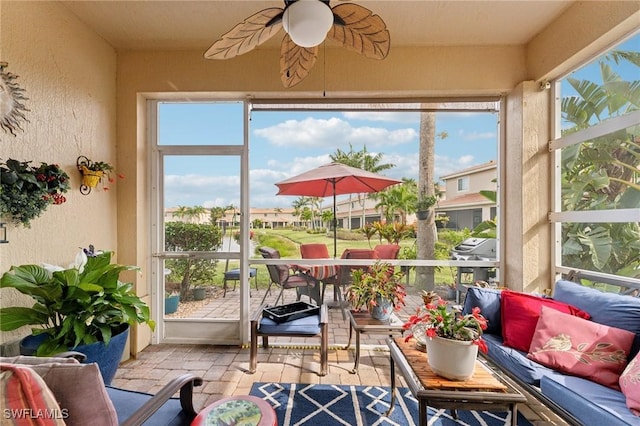 sunroom / solarium featuring ceiling fan