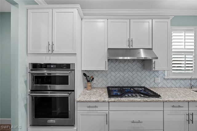 kitchen featuring white cabinets, appliances with stainless steel finishes, and decorative backsplash