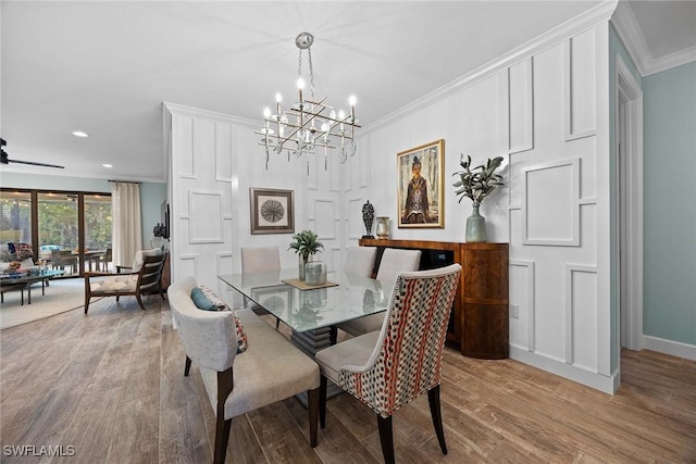 dining area with ceiling fan with notable chandelier, light hardwood / wood-style floors, and crown molding