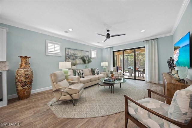 living room with crown molding, light hardwood / wood-style flooring, and a healthy amount of sunlight