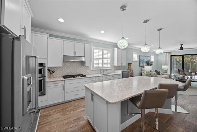 kitchen with ceiling fan, white cabinets, hanging light fixtures, and appliances with stainless steel finishes