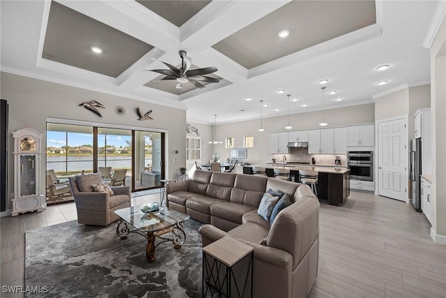 living room with a water view, ceiling fan, crown molding, and coffered ceiling