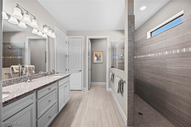 bathroom featuring a tile shower and vanity