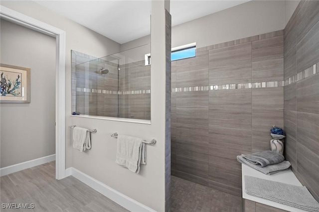 bathroom with hardwood / wood-style flooring and a tile shower