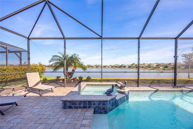 view of pool featuring glass enclosure, an in ground hot tub, a patio area, and a water view