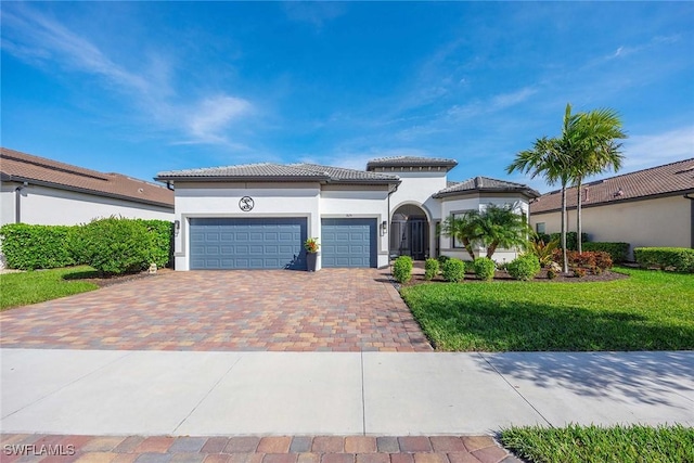 mediterranean / spanish house featuring a garage and a front lawn