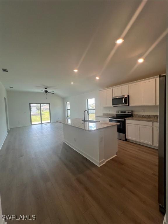 kitchen with sink, white cabinetry, a center island with sink, appliances with stainless steel finishes, and dark hardwood / wood-style flooring