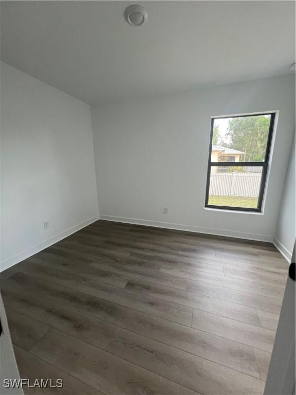 spare room with dark wood-type flooring