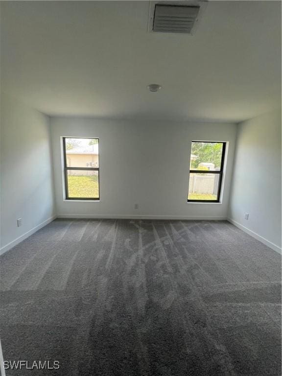 empty room featuring dark colored carpet