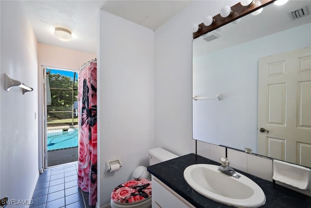 bathroom featuring tile patterned flooring, vanity, and toilet