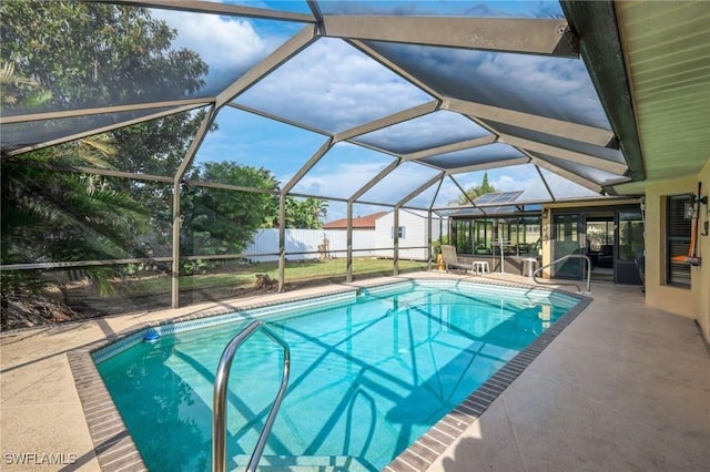 view of pool featuring glass enclosure and a patio