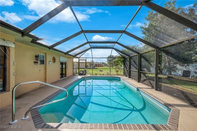 view of pool with glass enclosure and a patio area