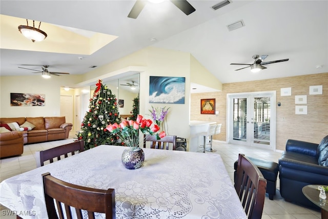 dining area with french doors, lofted ceiling, and light tile patterned flooring