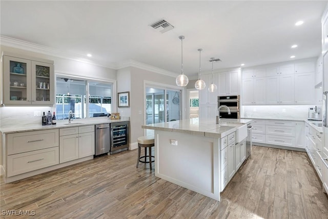 kitchen featuring wine cooler, sink, an island with sink, and stainless steel appliances