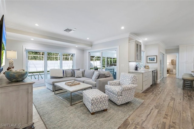 living room featuring light hardwood / wood-style floors, beverage cooler, and crown molding