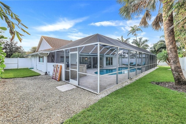 back of property featuring a patio area, a lanai, a fenced in pool, and a yard