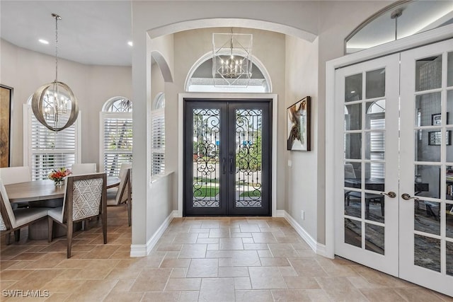 foyer with french doors and a chandelier