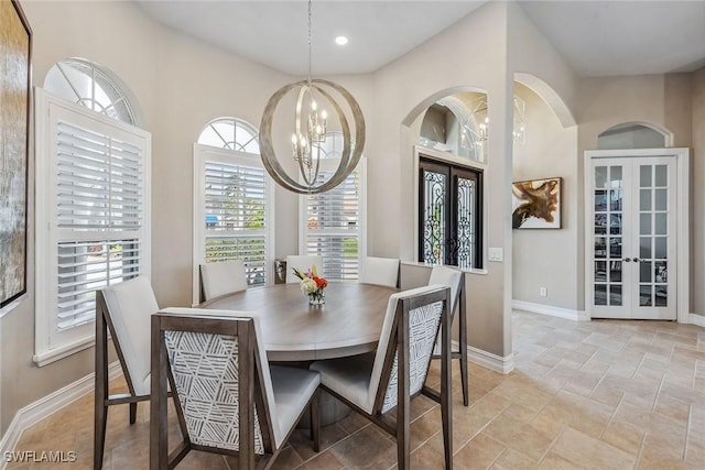 dining area featuring french doors, plenty of natural light, and a notable chandelier