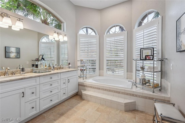 bathroom featuring vanity and tiled tub