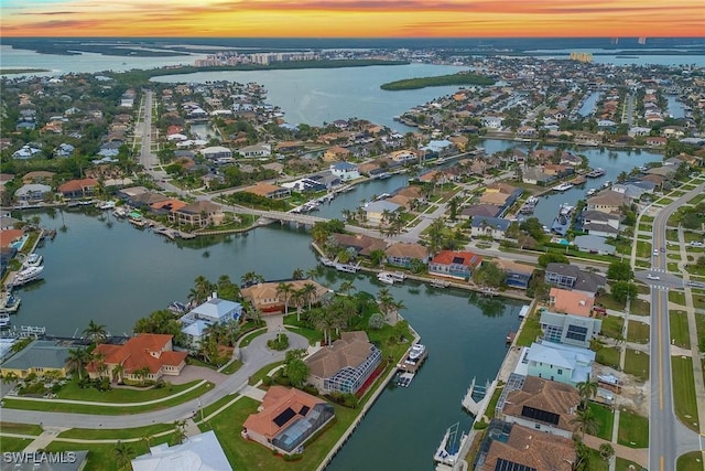 aerial view at dusk featuring a water view