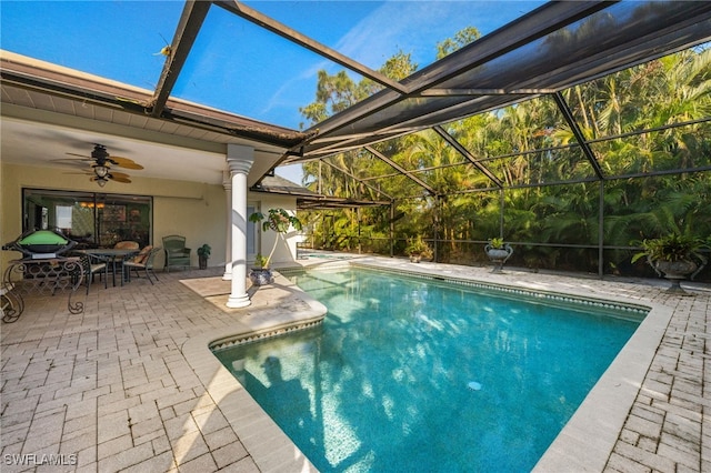 view of swimming pool with ceiling fan, a patio area, and a lanai