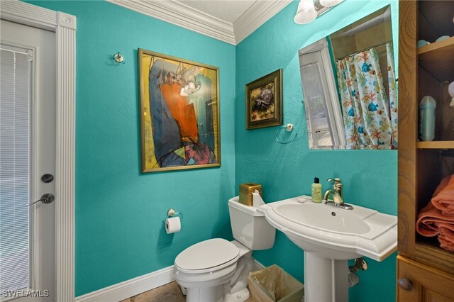 bathroom with a shower with curtain, toilet, and ornamental molding