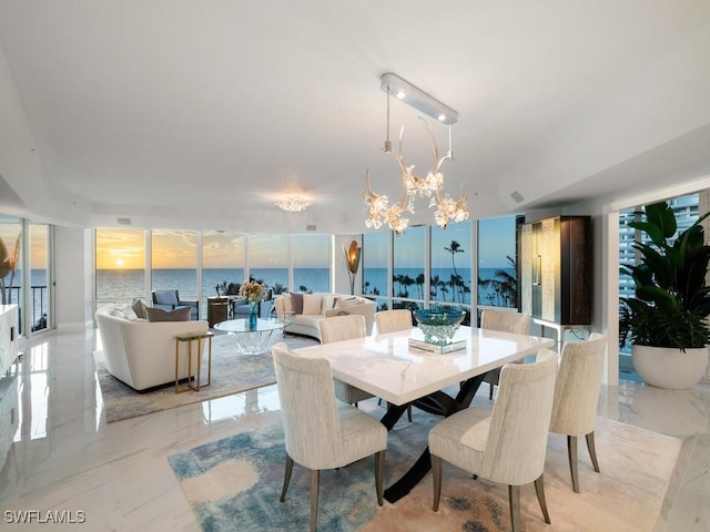 dining room featuring a water view and an inviting chandelier