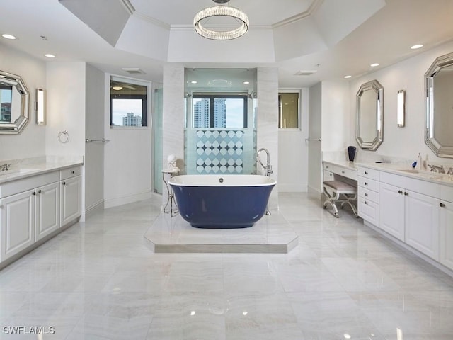 bathroom with a tub, vanity, and ornamental molding