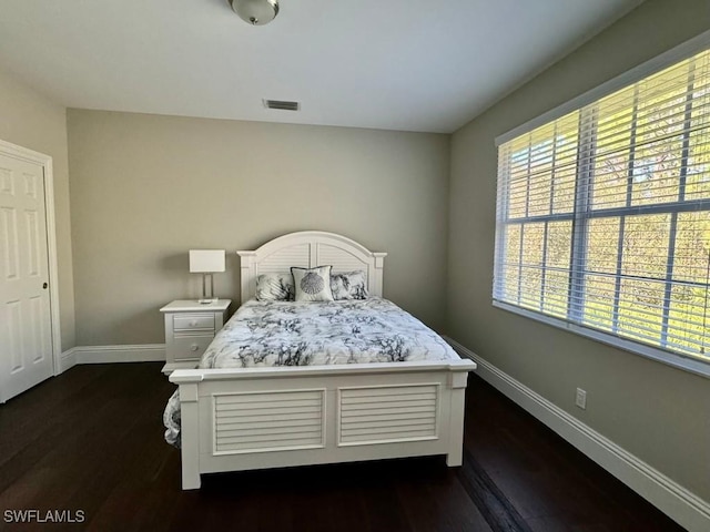 bedroom with dark hardwood / wood-style flooring