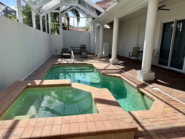 view of pool featuring an in ground hot tub, a patio, ceiling fan, and a lanai