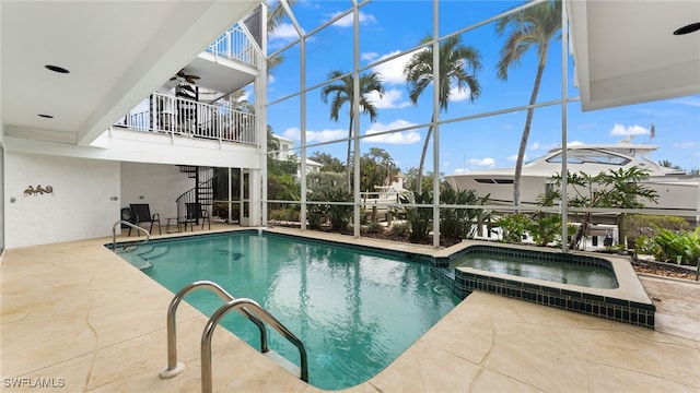 view of swimming pool featuring ceiling fan, a patio area, and an in ground hot tub