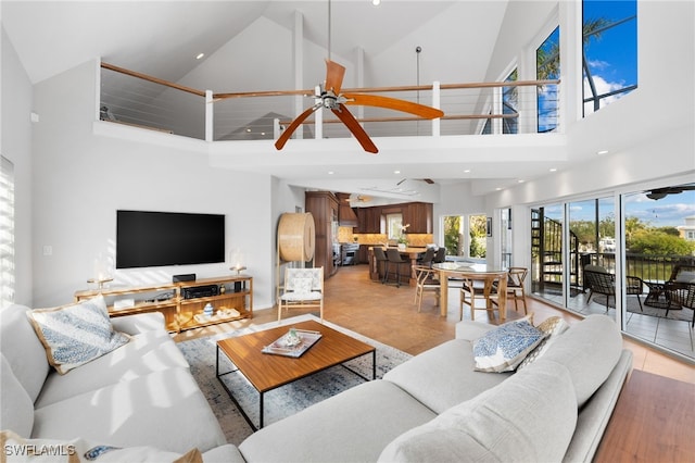 living room featuring ceiling fan, high vaulted ceiling, and light tile patterned flooring