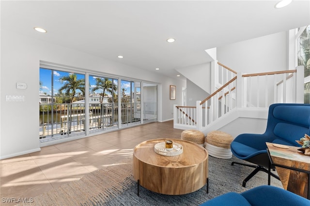 sitting room with a water view and light tile patterned flooring