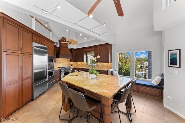 dining space with ceiling fan, sink, light tile patterned floors, and high vaulted ceiling