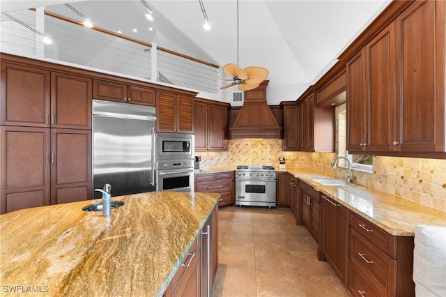 kitchen with tasteful backsplash, custom range hood, sink, built in appliances, and lofted ceiling